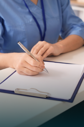 Dental team member writing on a clipboard