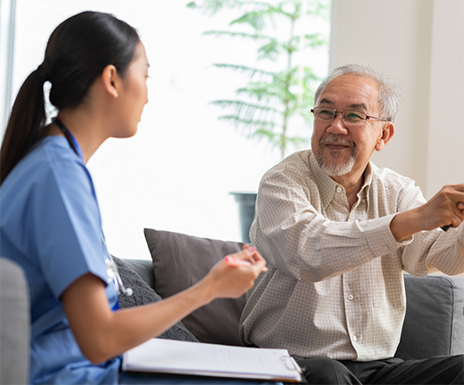 Dental team member talking to a senior man
