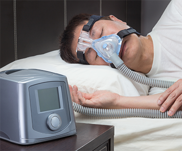 SLeeping man wearing a CPAP mask
