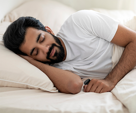Sleeping man with a pulse oximeter on his finger