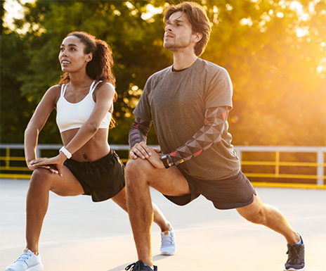 Man and woman in exercise clothing stretching outdoors